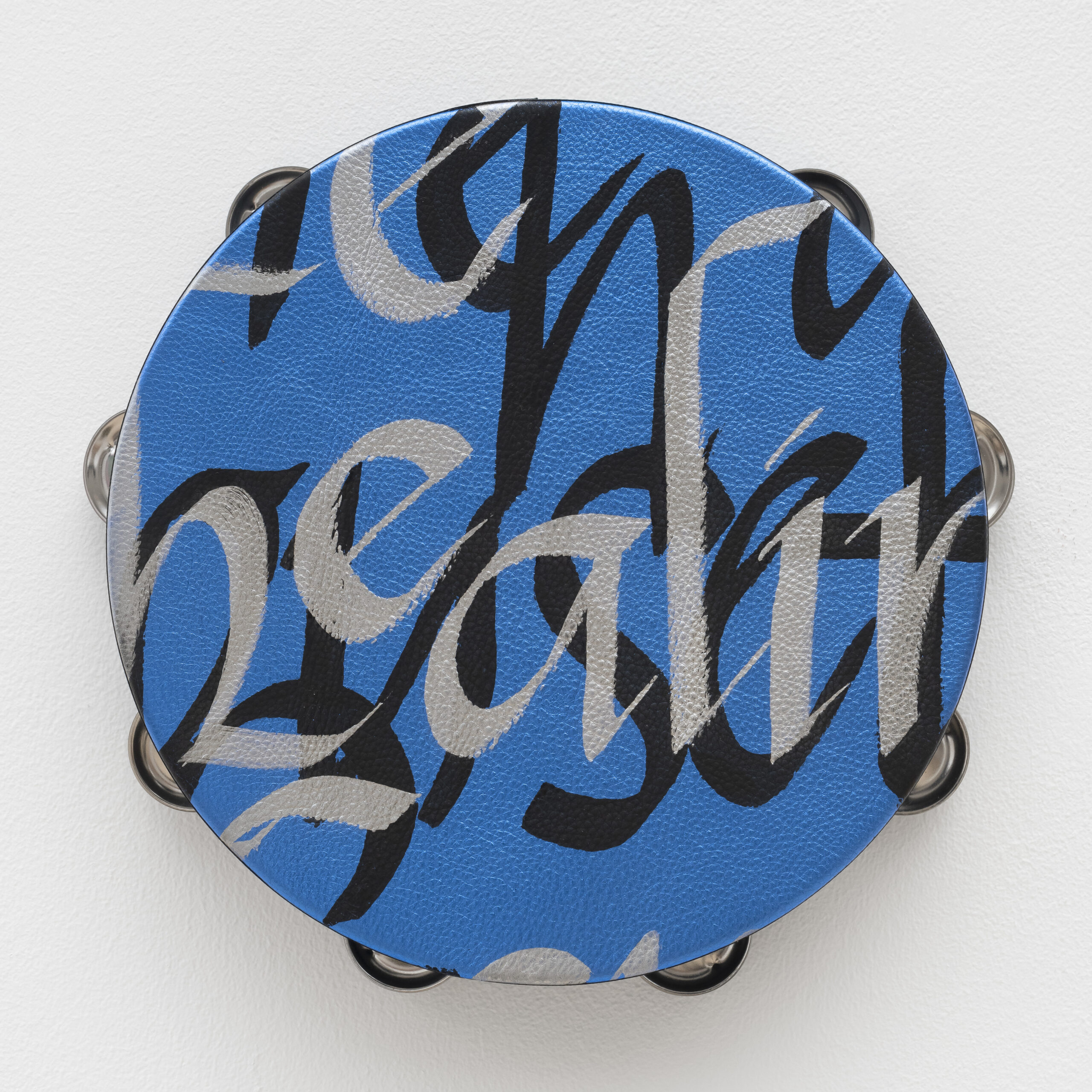 Lava Thomas<br><em>Healing Power</em>, 2025<br>Altered tambourines, acrylic calligraphy on metallic leather, acrylic disks, and grosgrain ribbon<br>11 x 11 x 2 inches / 27.9 x 27.9 x 5.1 cm