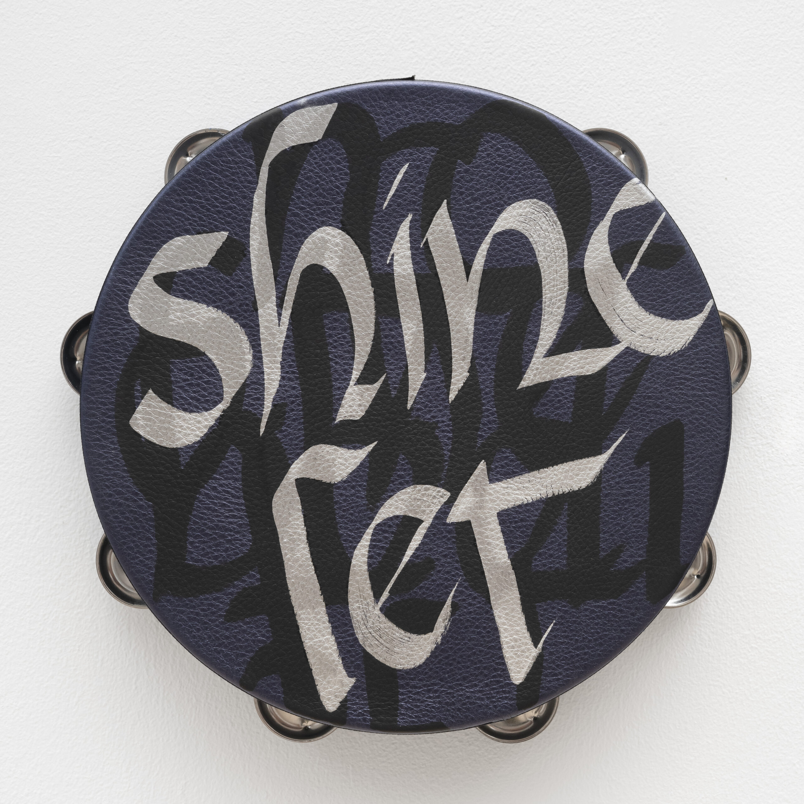 Lava Thomas<br><em>Let it Shine</em>, 2025<br>Altered tambourines, acrylic calligraphy on metallic leather, acrylic disks, and grosgrain ribbon<br>11 x 11 x 2 inches / 27.9 x 27.9 x 5.1 cm