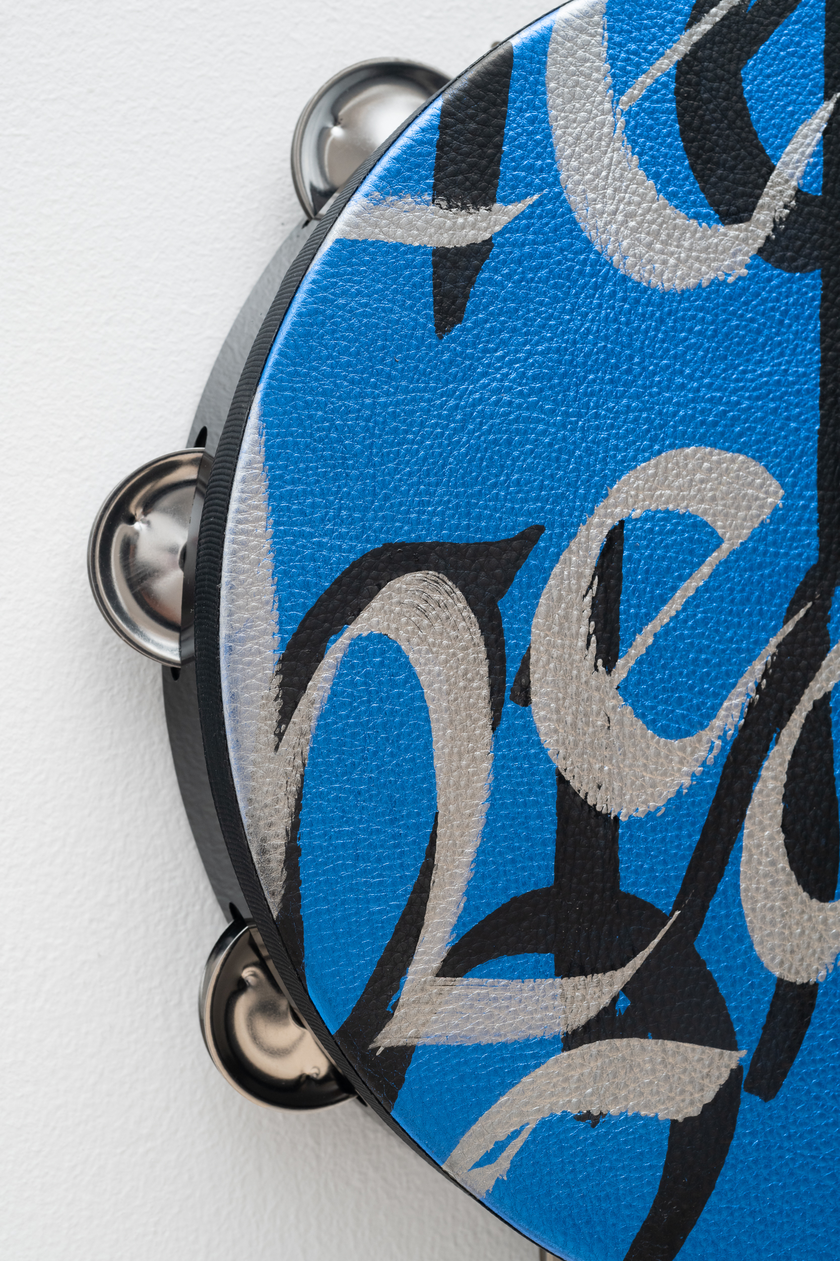 <p>Lava Thomas<br /><em>Healing Power</em>, 2025<br />Altered tambourines, acrylic calligraphy on metallic leather, acrylic disks, and grosgrain ribbon<br />Detail view</p>
