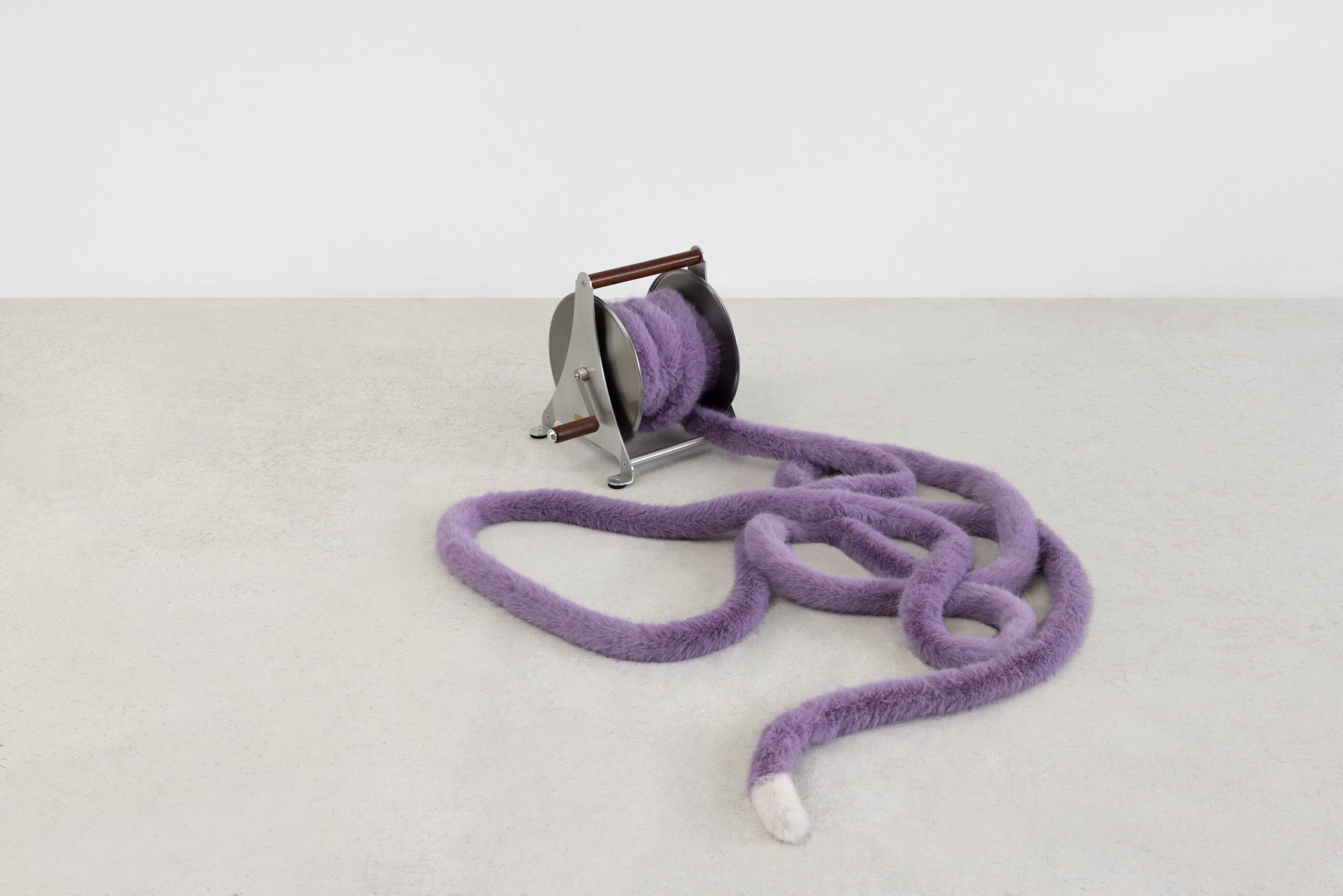 <p>Nicole Wermers<br />
<i>Domestic Tail (purple, 13 metres)</i>, 2026<br />
Stainless steel hose wheel with wooden handles and a hand sewn faux fur tail with polyester filling<br />
19 1/4 x 15 3/4 x 19 1/4 inches / 49 x 40 x 49 cm</p>
