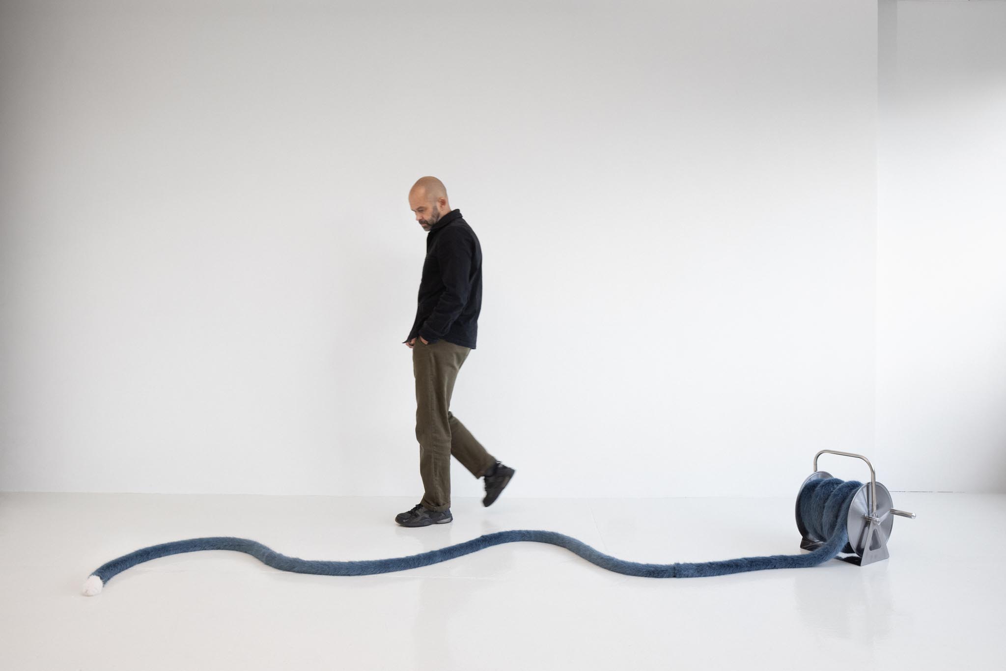 Nicole Wermers<br><em>Domestic Tail (Petrol Blue/White tip, 11 Meters)</em>, 2026<br>Handsewn faux fur tail, polystyrene filling, thread, and hose reel<br>Hose wheel: 17 3/4 x 16 7/8 x 13 inches / 45 x 43 x 33 cm<br>Tail length: 433 inches / 1099.8 cm